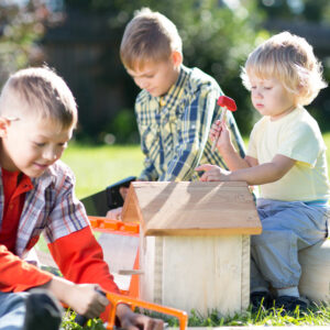 Kinder spielen mit Holzresten